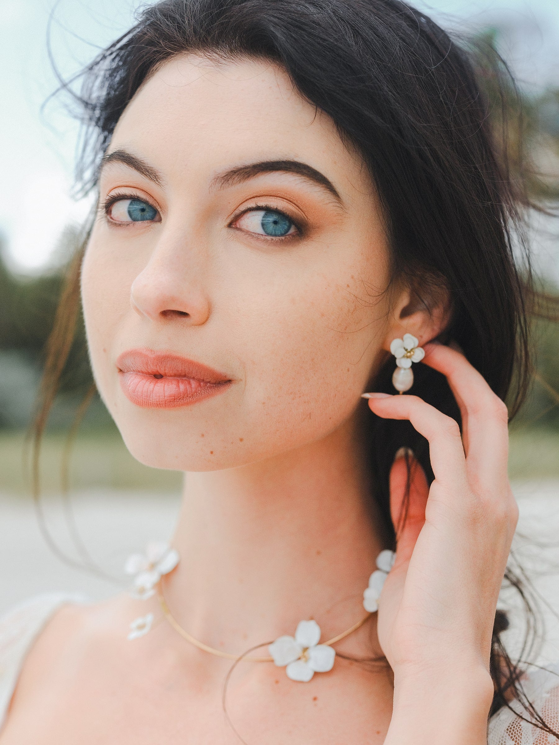 Set di gioielli elegante con collana e orecchini a fiori bianchi, perfetto per una sposa raffinata.