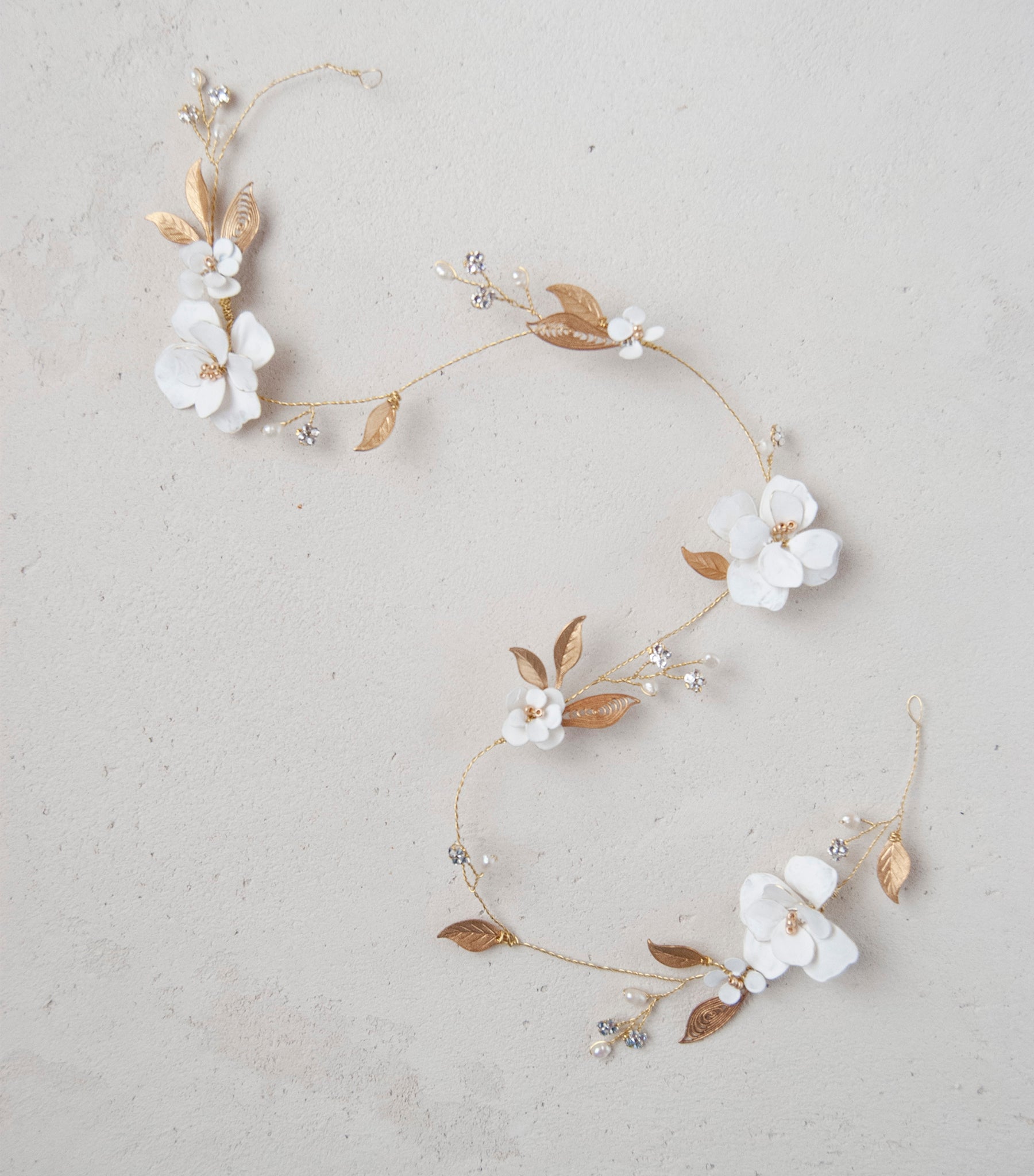 Accessorio capelli elegante: filo gioiello con fiori e foglie dorate, per spose moderne.