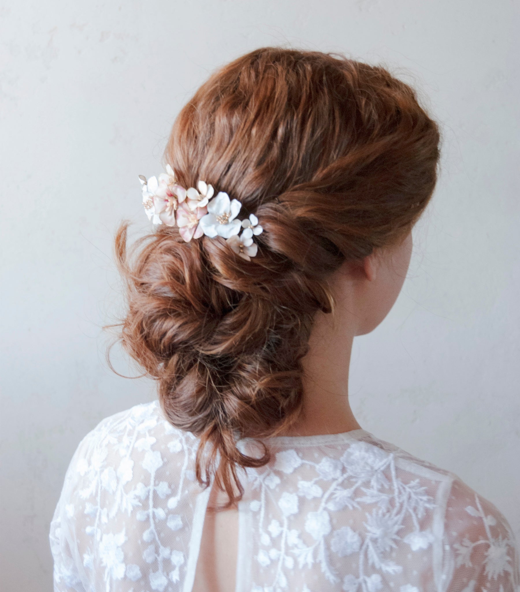 Elegante pettinino per capelli con fiori bianchi e rosa, perfetto per una sposa chic.