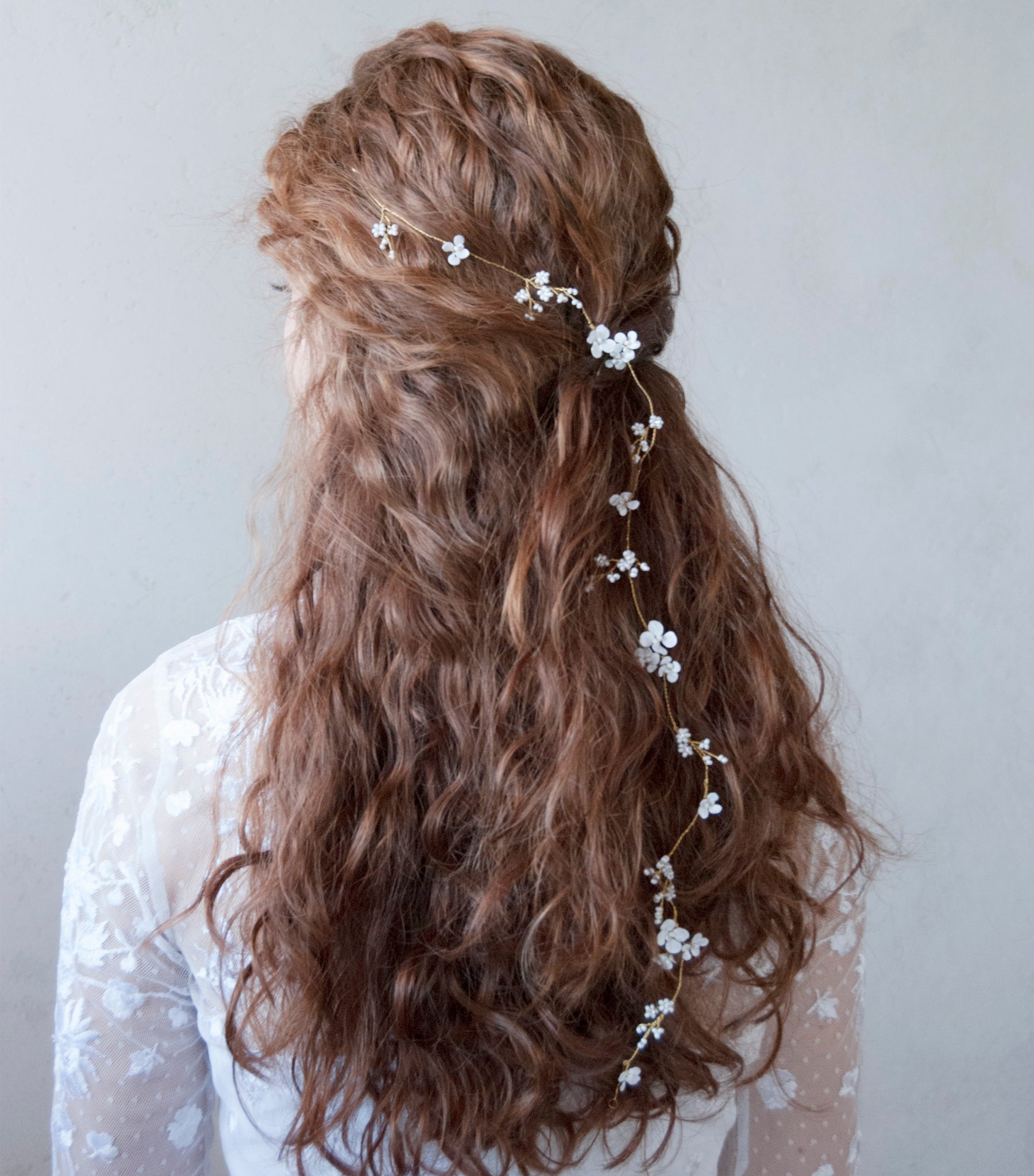 Accessorio floreale per capelli, decorato con fiorellini bianchi delicati.