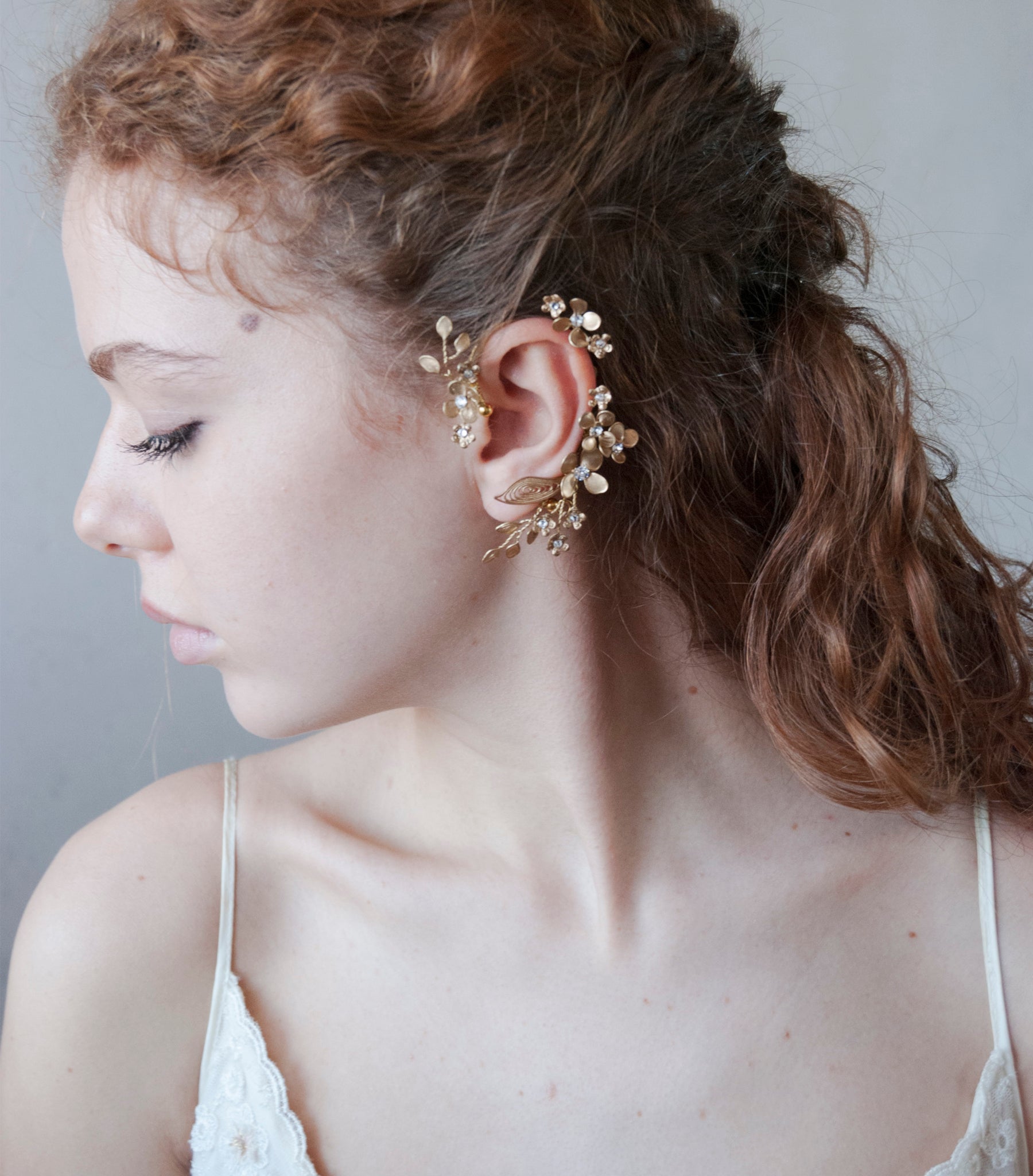 Accessorio orecchio: ear cuff dorato con design floreale delicato.