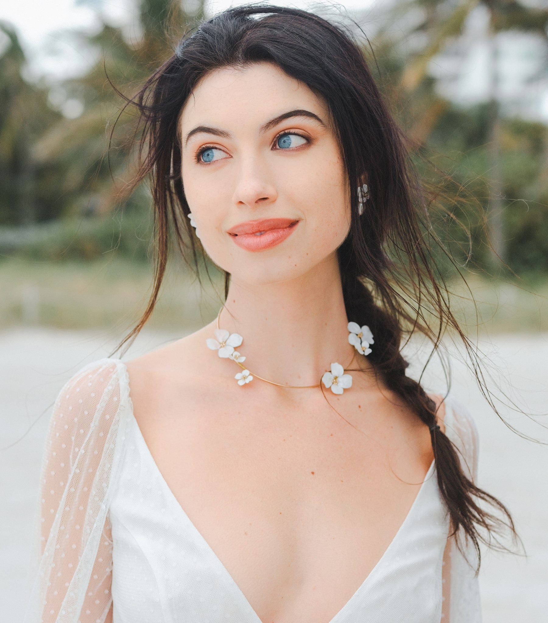 Collana con fiori bianchi, un accessorio floreale che dona un tocco romantico e delicato al tuo look da sposa.