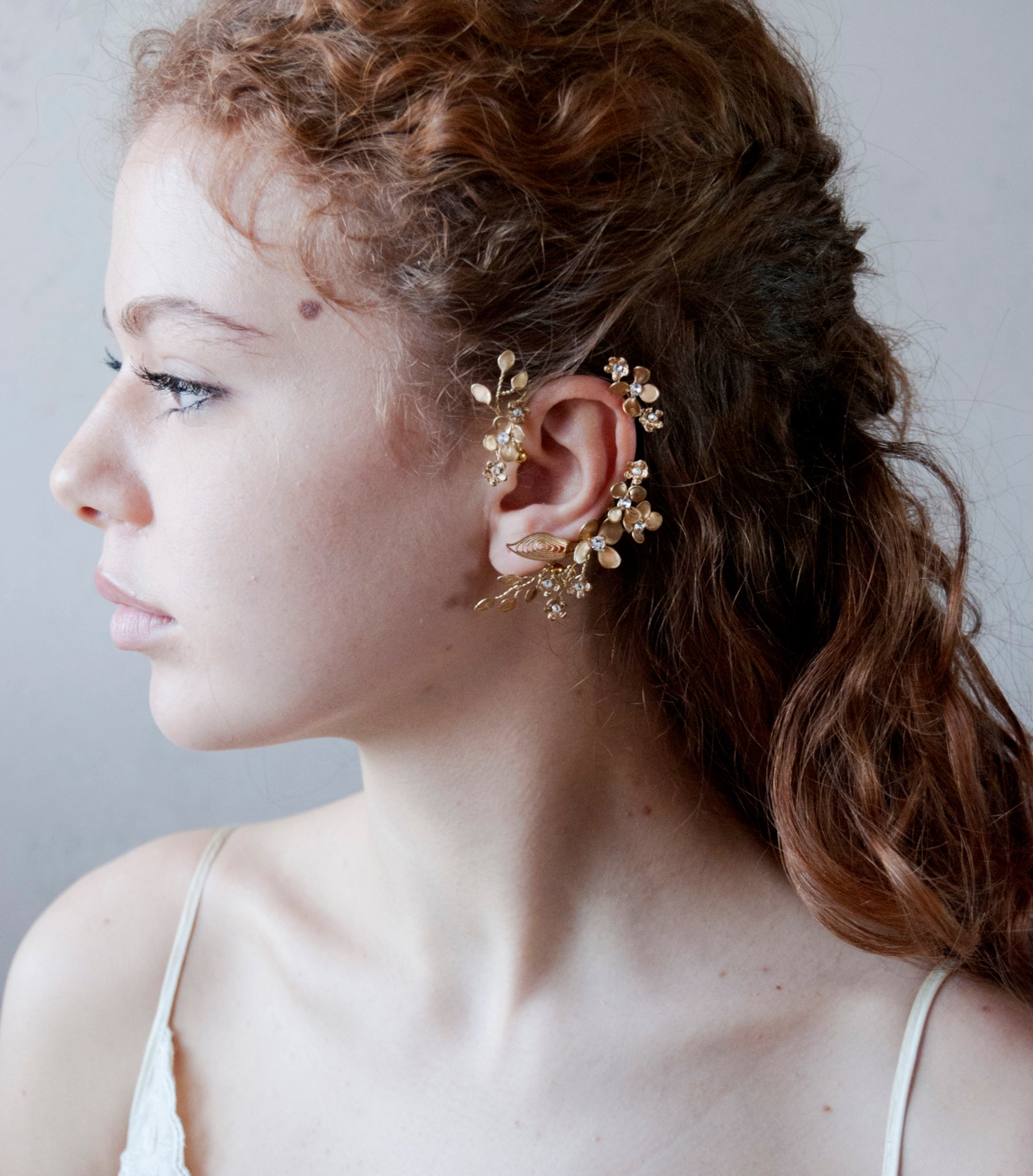 Ear cuff elegante dorato con motivi floreali, ideale per cerimonie speciali.