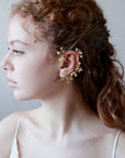 Ear cuff elegante dorato con motivi floreali, ideale per cerimonie speciali.