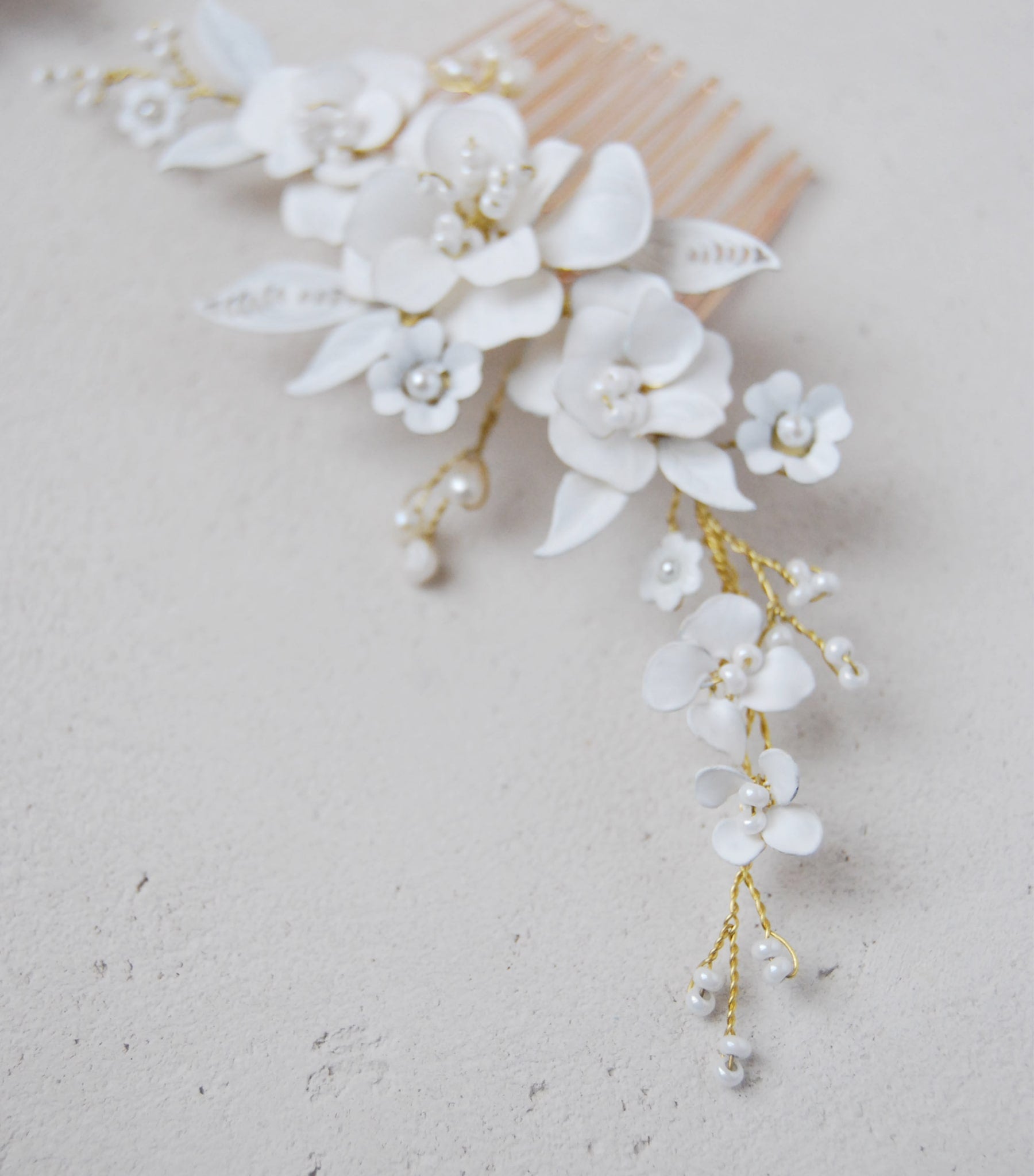 Accessorio sposa: fermagli con fiori e foglie bianche per un look delicato.