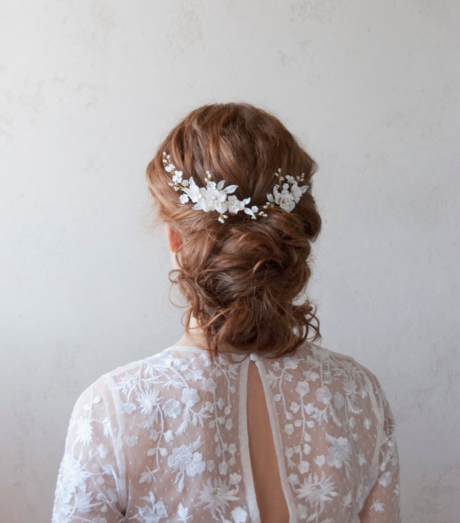 Fermagli per matrimonio con dettagli di fiori e foglie bianche, stile raffinato.