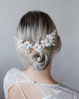 Accessorio per acconciature da sposa con peonie bianche e fiorellini decorativi.