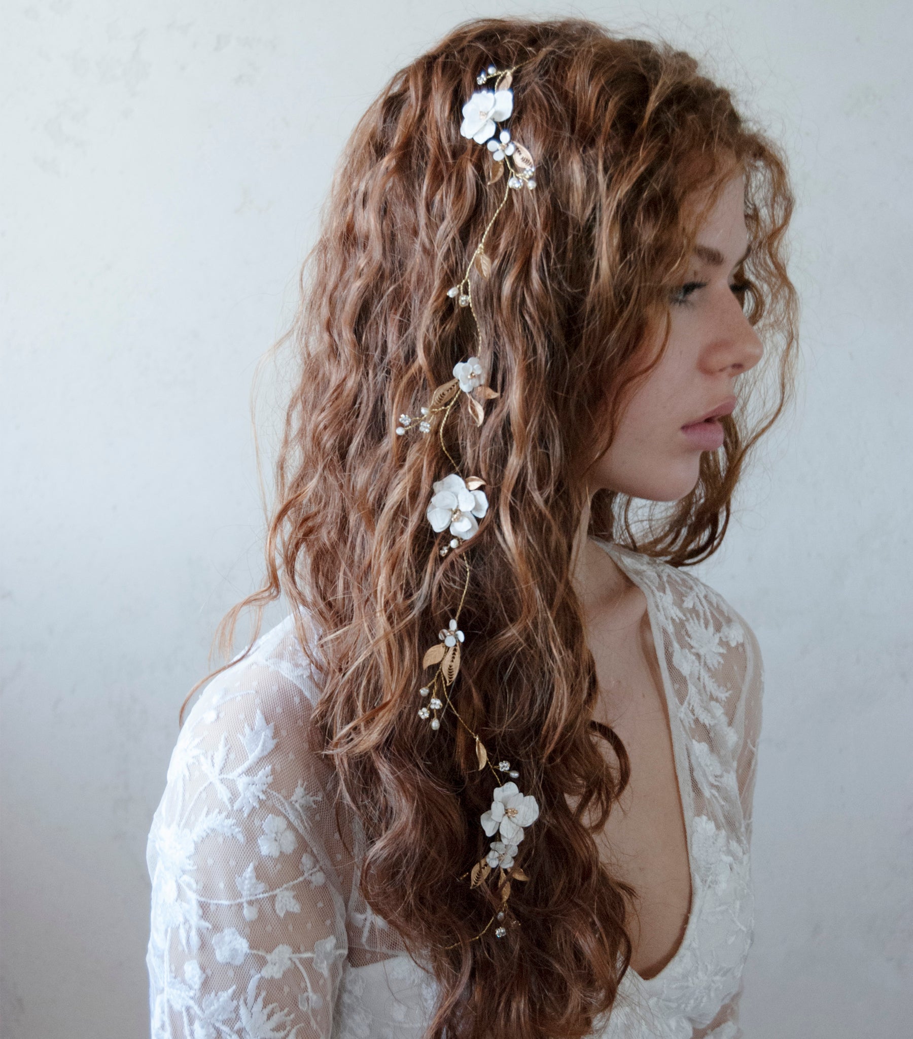 Filo gioiello decorato con fiori e foglie dorate, perfetto per una sposa moderna.