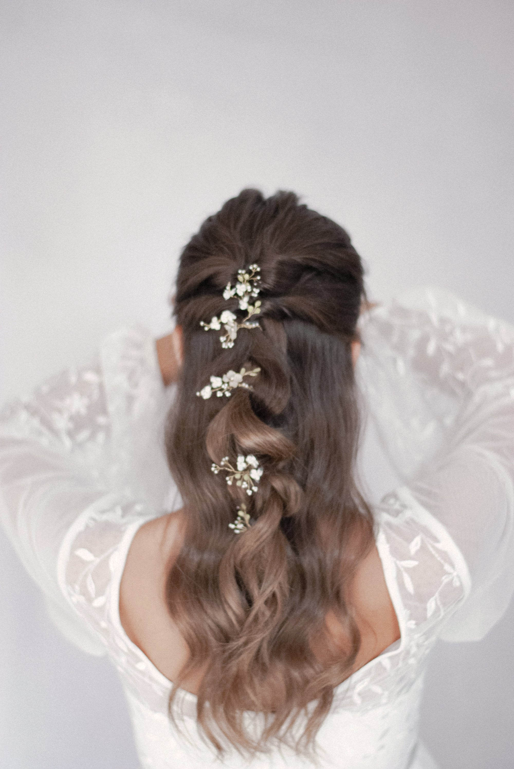 Forcine artigianali Nebbiolina per capelli, con fiori di pizzo, per un&#39;acconciatura da sposa elegante.

