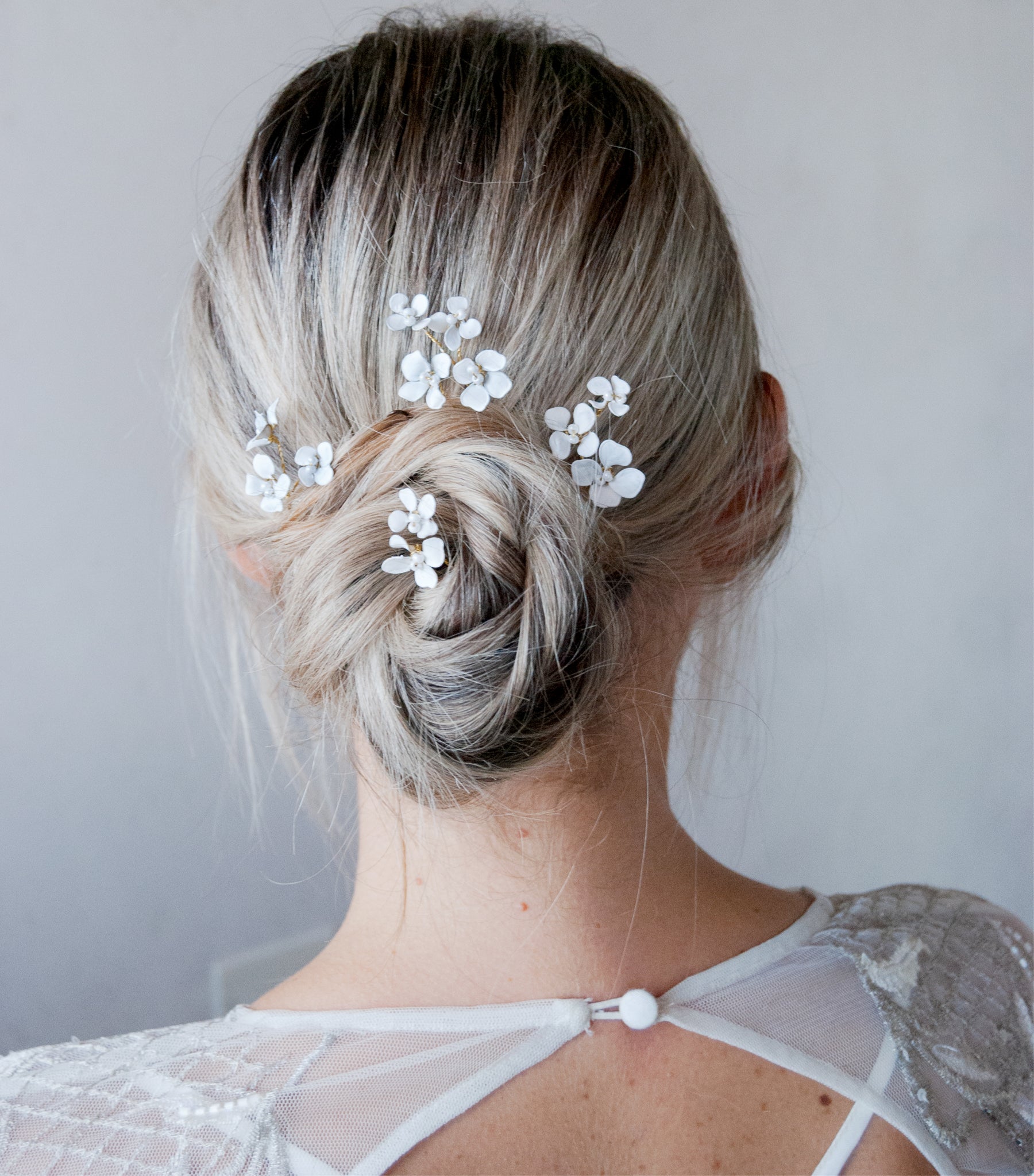 Forcine per acconciature da sposa, decorate con fiorellini bianchi per un look elegante.