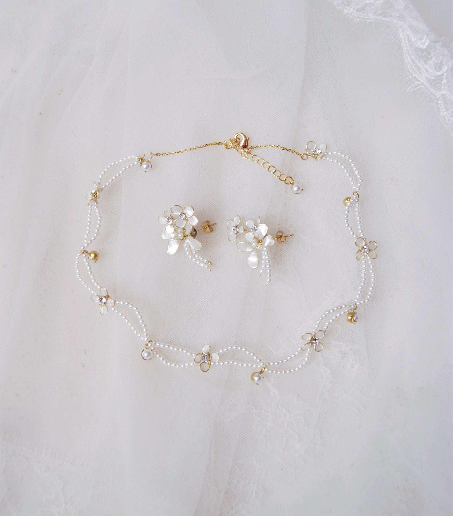 Set di gioielli per matrimonio con collana e orecchini, perfetti per un look da sposa elegante e coeso, con dettagli floreali e perline luminose.