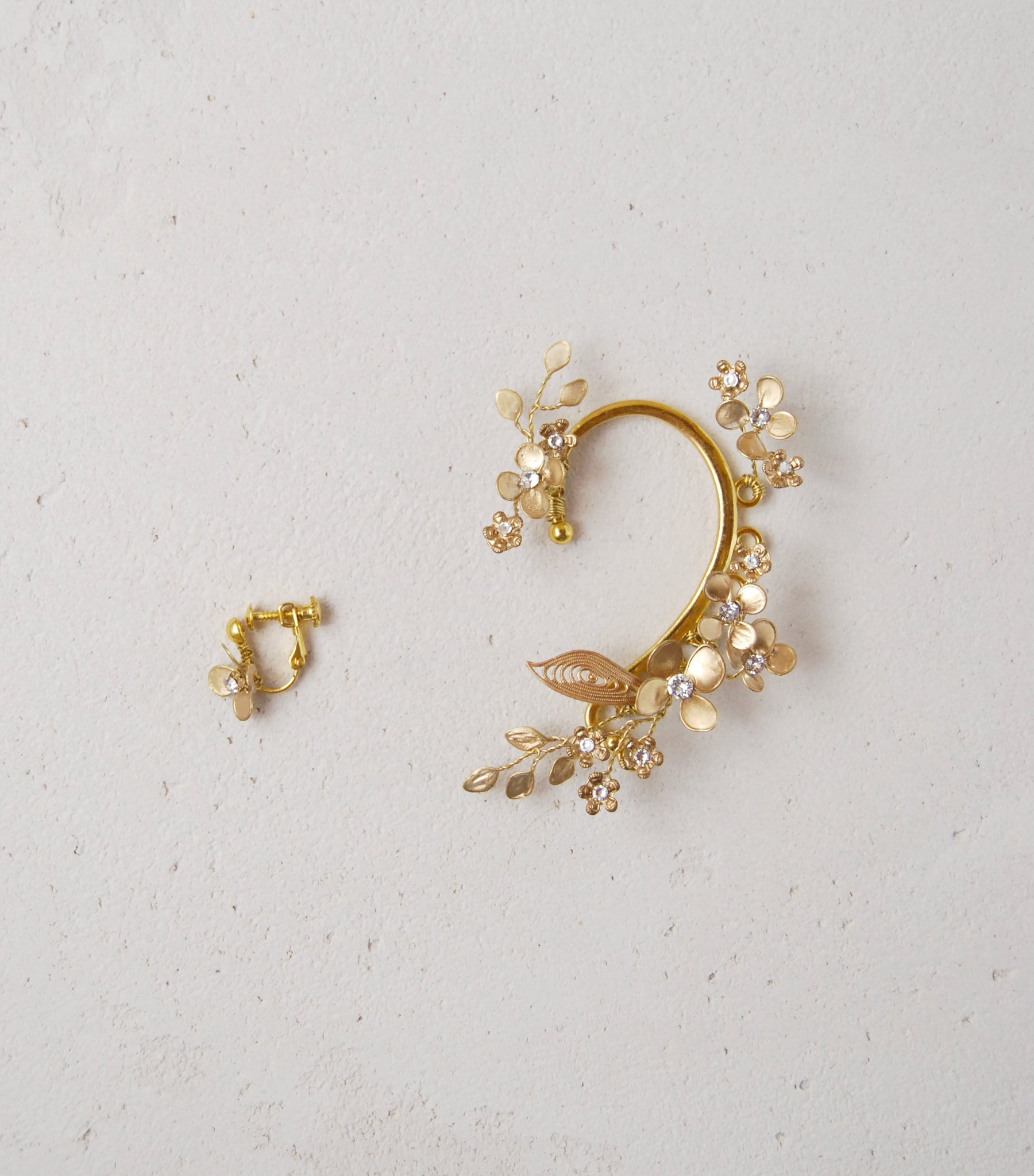 Gioiello da sposa: ear cuff dorato con dettagli floreali raffinati.