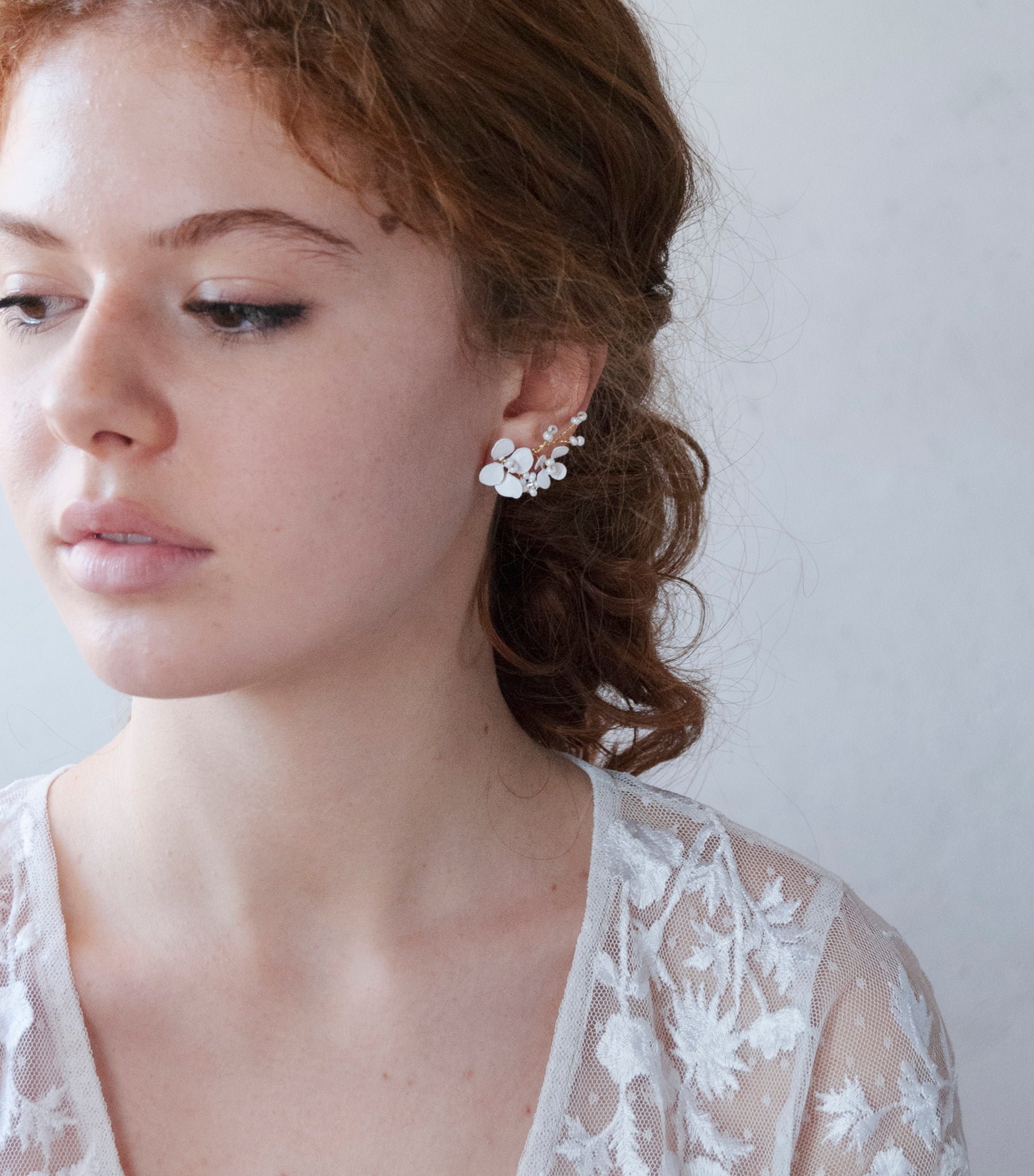 Eleganti orecchini rampicanti con fiori bianchi, ideali per un look da sposa moderno e chic.