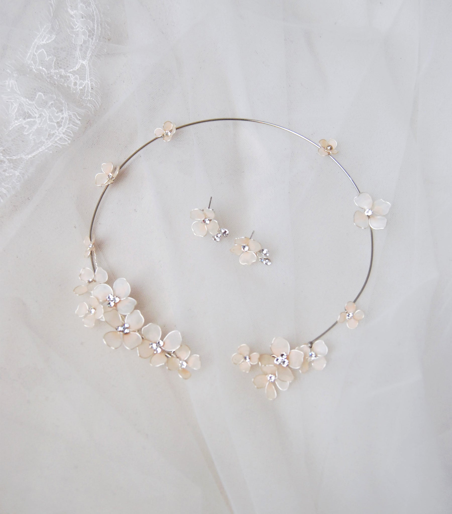 Set da sposa con collana e orecchini decorati con fiori rosa satinati per un look raffinato.