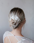 Accessorio per capelli bianco con peonie e fiorellini, aggiunge eleganza al look nuziale.