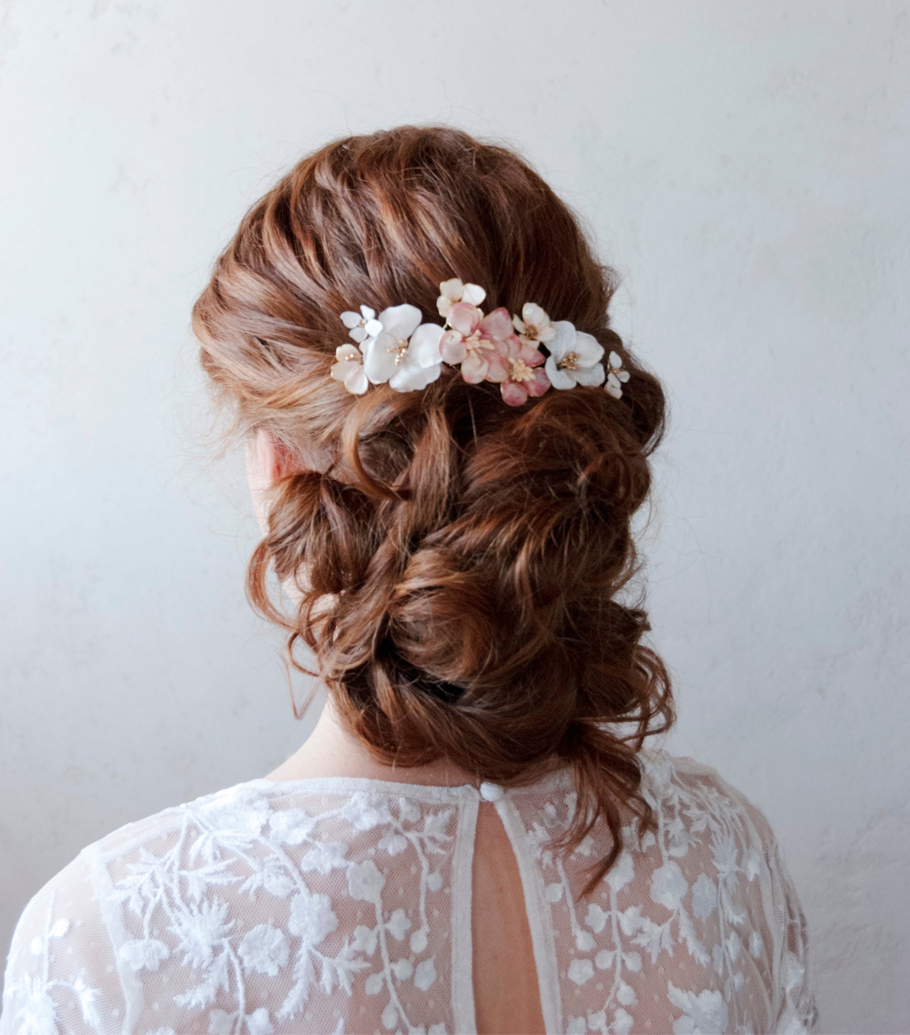 Accessorio floreale con fiori bianchi e rosa, perfetto per un matrimonio all&#39;aperto.