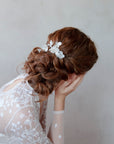 Elegante pettinino con fiori madreperlati, un accessorio unico per capelli da sposa.