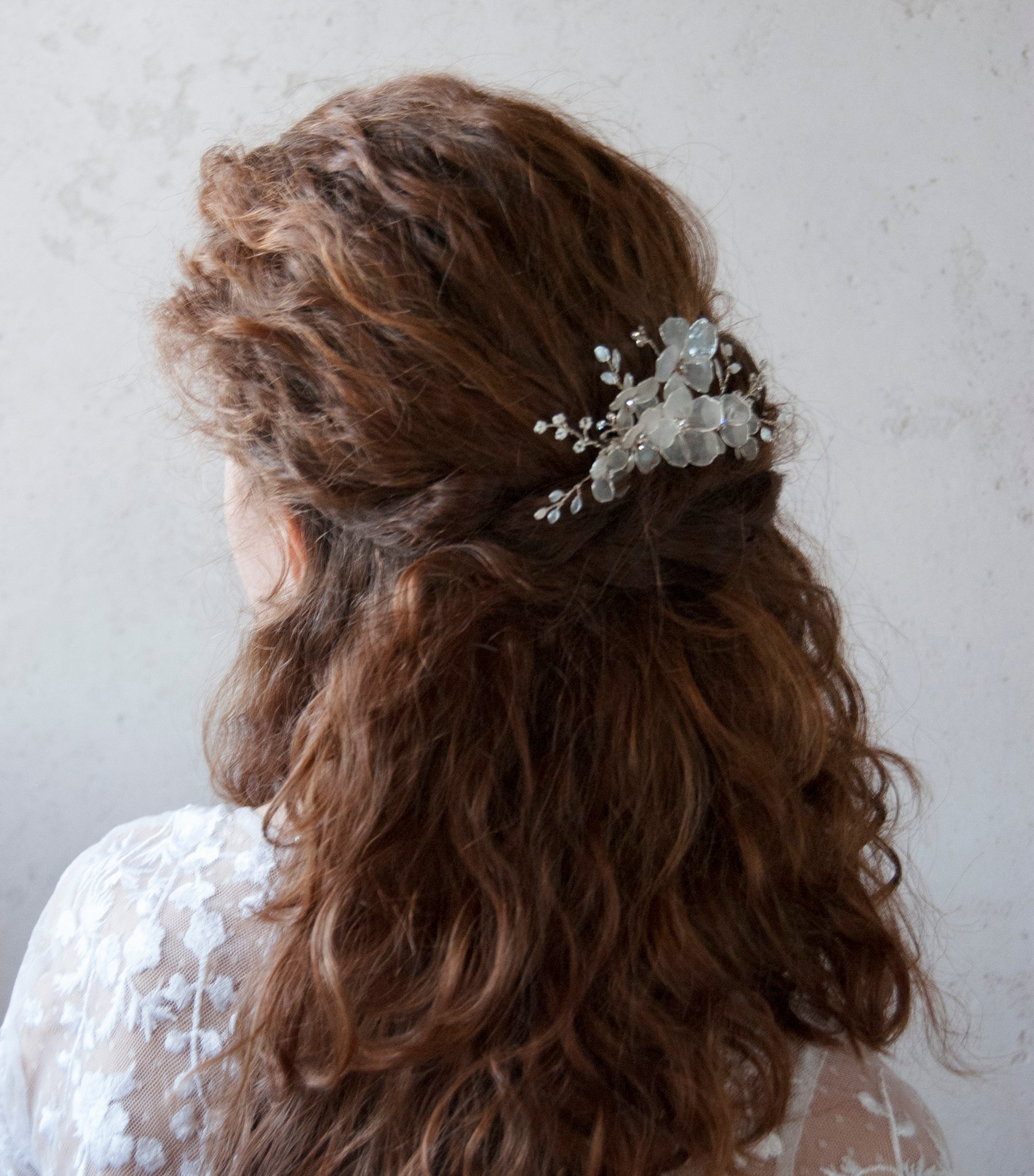 Elegante pettinino con fiori satinati, il dettaglio perfetto per il matrimonio da sogno.