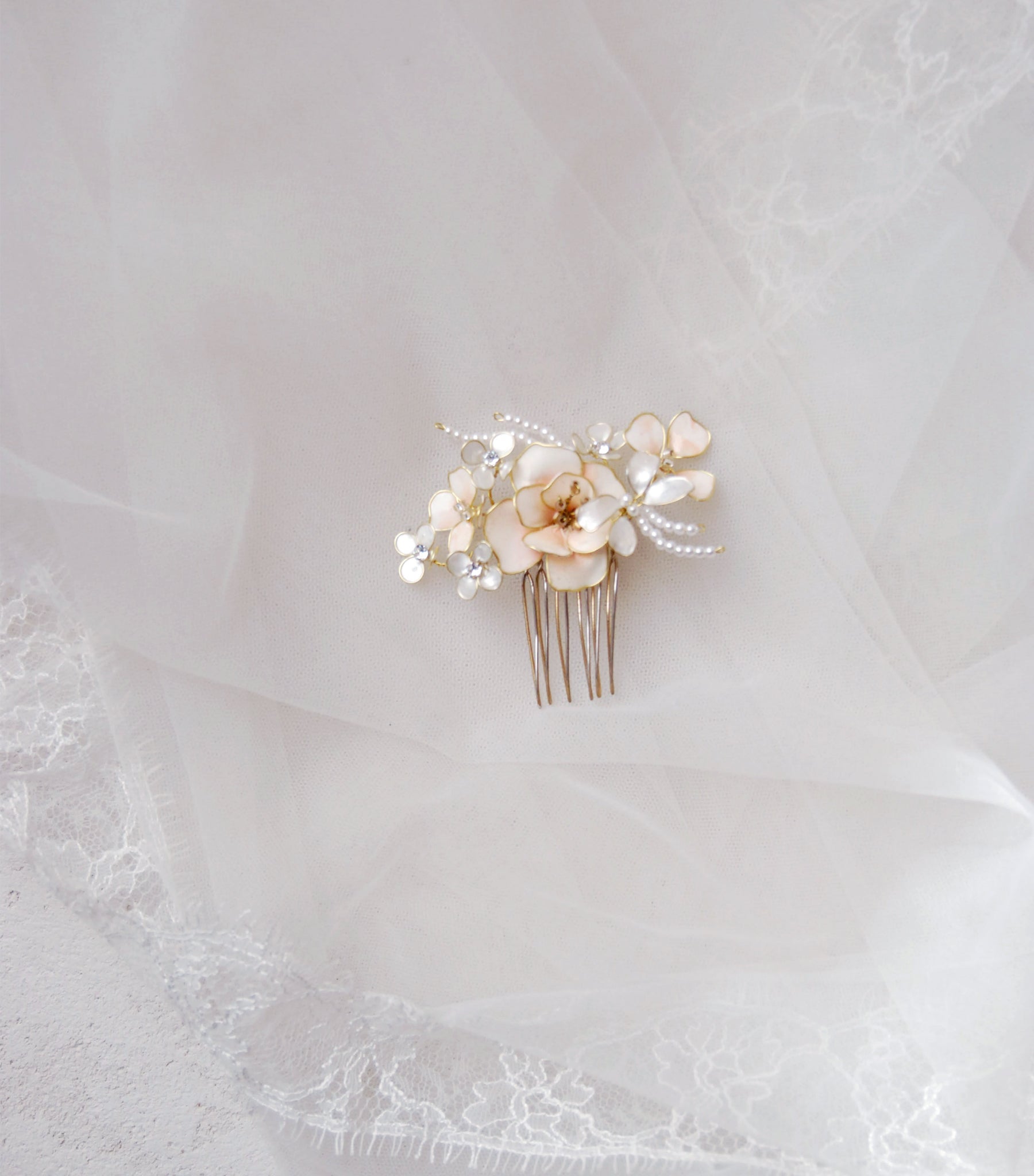 Accessorio da sposa con pettinino rosa e fiori madreperlati, perfetto per acconciature raffinate.