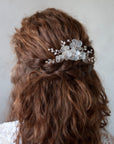 Accessori per capelli da sposa con fiori satinati, ideali per un’acconciatura raffinata.