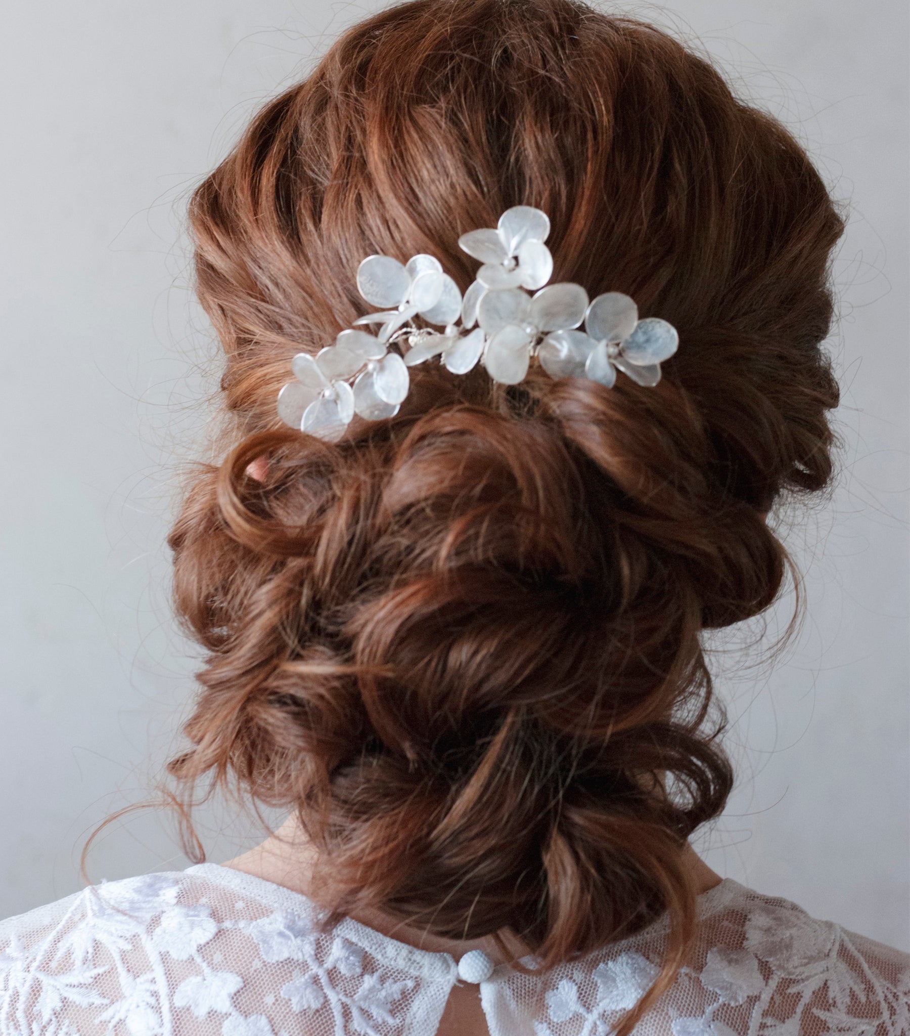 Pettinino da sposa con fiori madreperlati, un accessorio dai dettagli chic e luminosi.