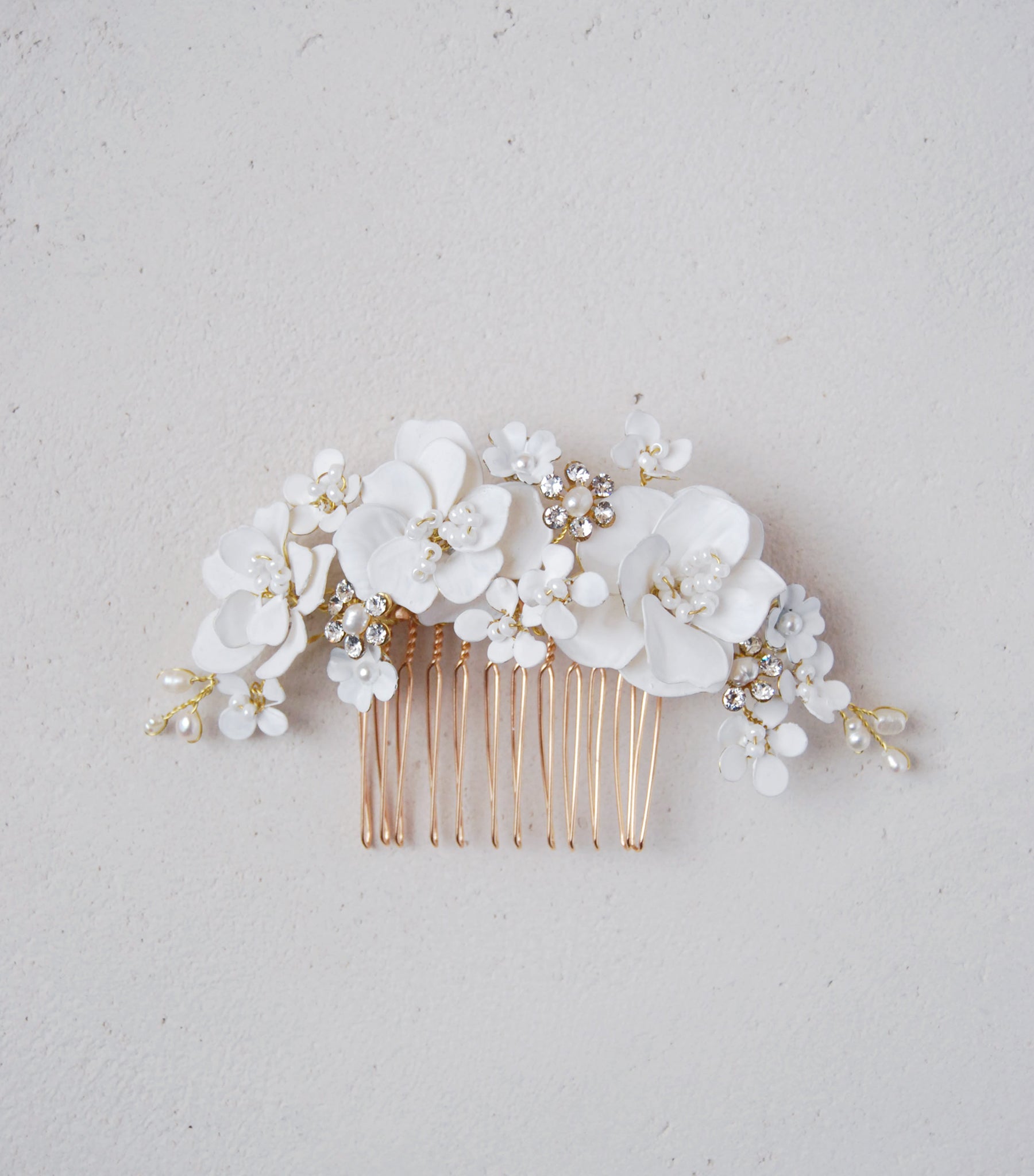 Accessorio per capelli con peonie e fiorellini bianchi, perfetto per acconciature da sposa.