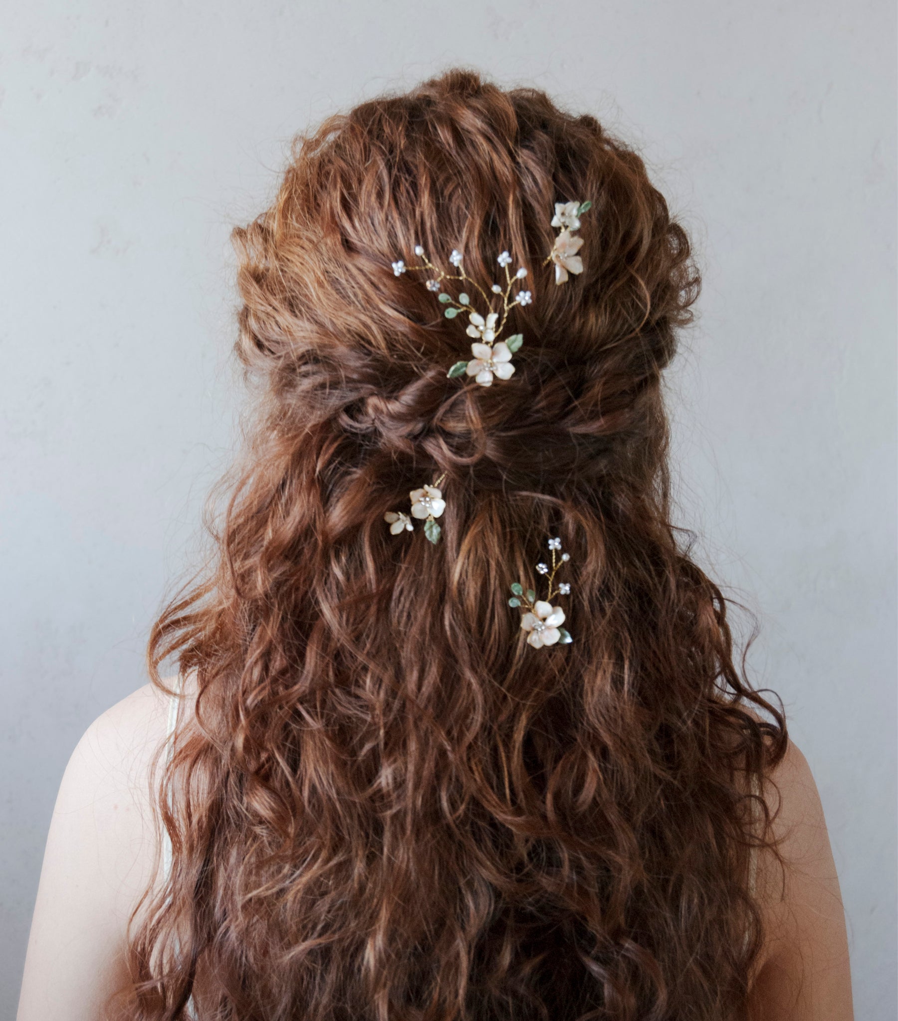 Set di forcine per matrimonio boho con fiori e foglie verdi rampicanti, per una sposa naturale e sofisticata.